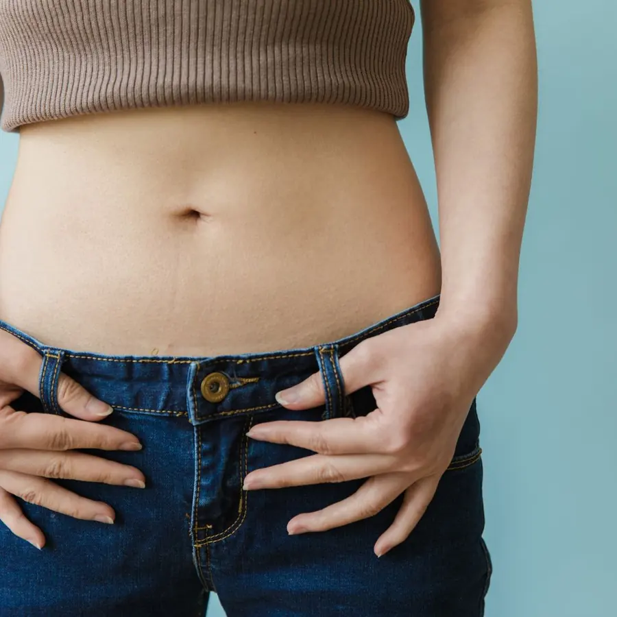 Mulher com as mãos na cintura mostrando o abdômen