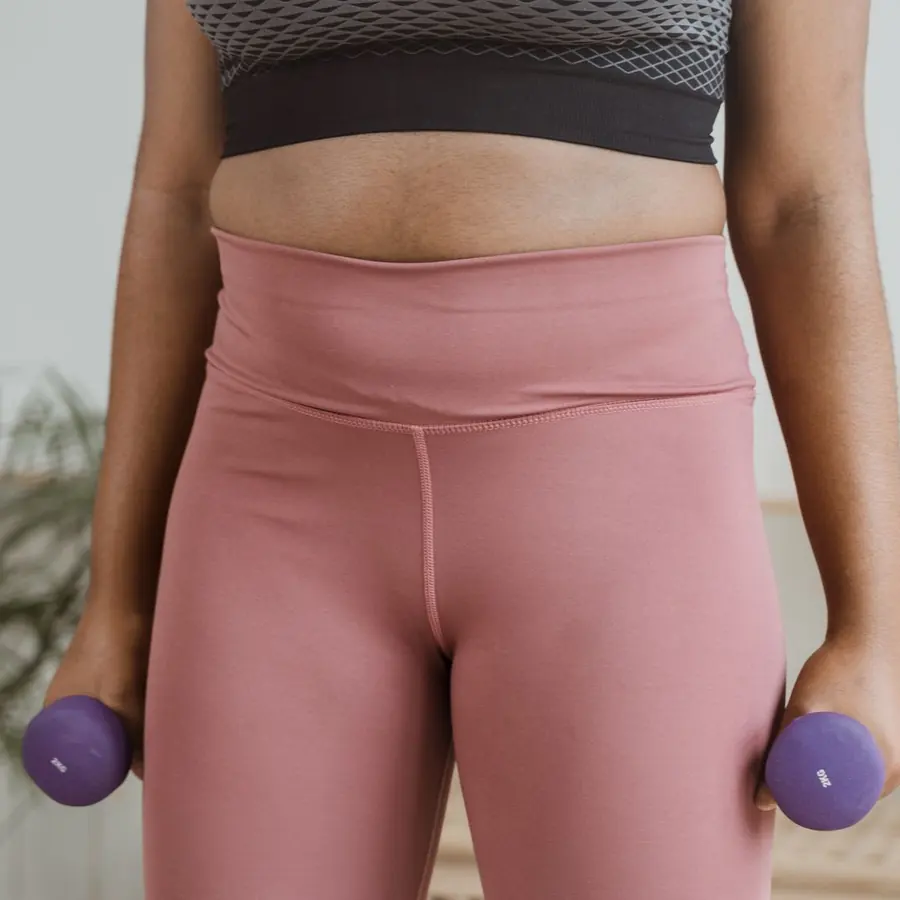 Abdômen definido de mulher em roupa de treino