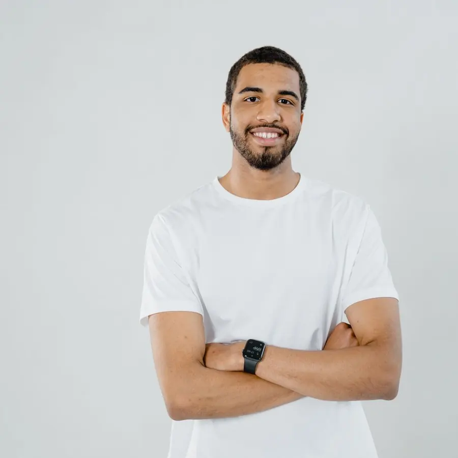 Homem de camiseta branca de braços cruzados